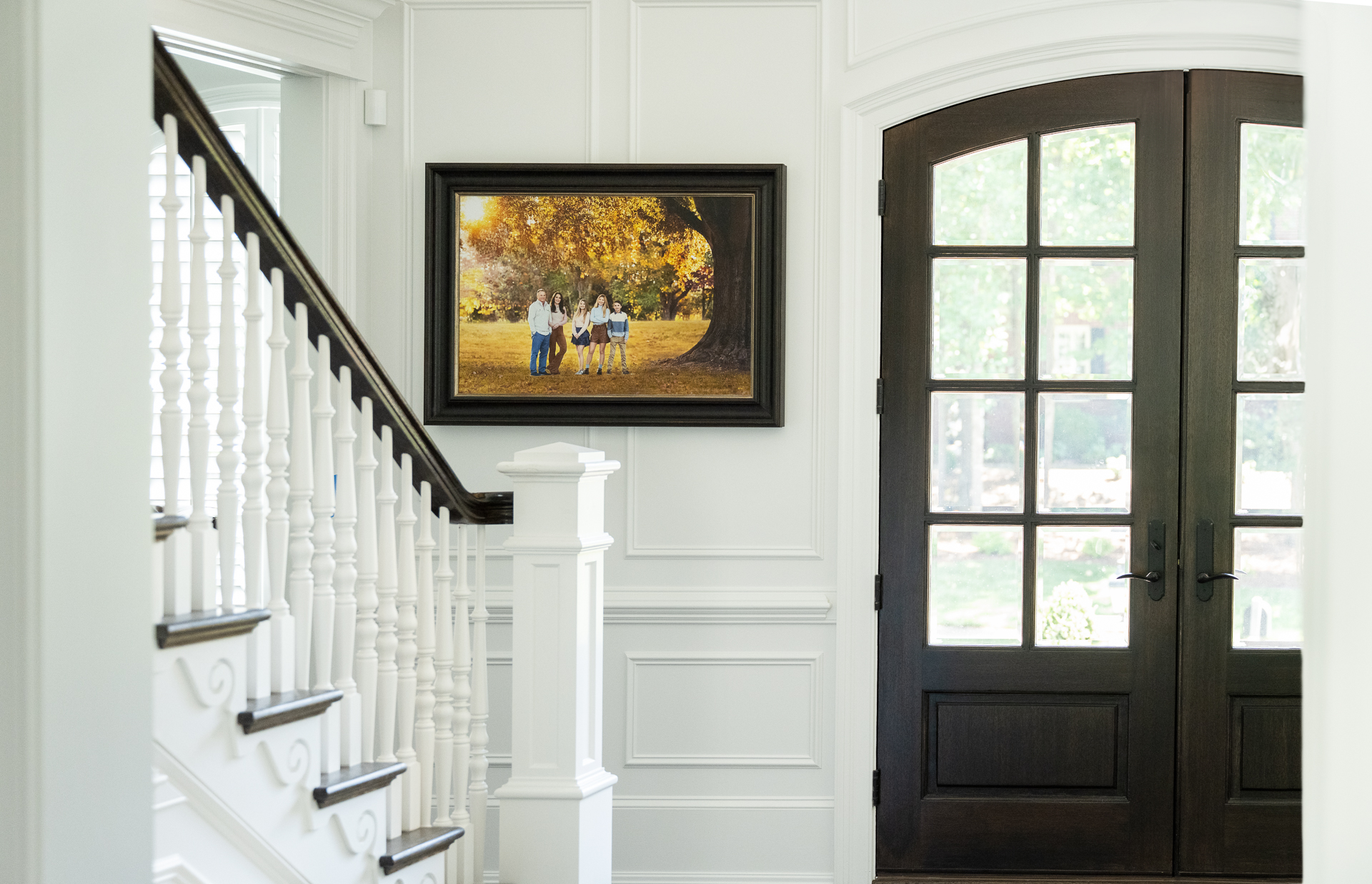 A picture of a framed family portrait hung in a foyer of a beautiful home in Williamsburg, VA