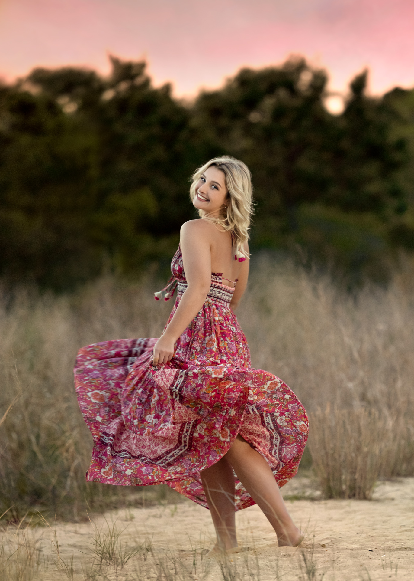 Photo of a girl twirling on a grassy beach at sunset in Williamsburg, VA, taken by Marika H Photography
